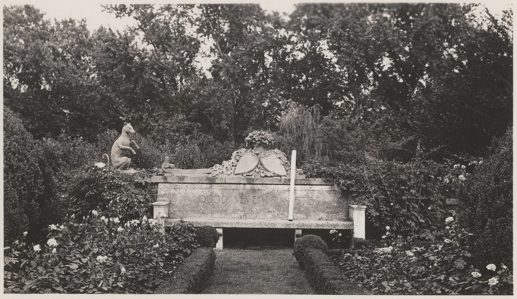 Archival photograph showing bench flanked by statue of dog.