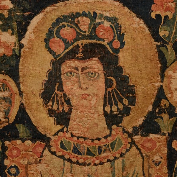 Close-up detail of a tapestry featuring a richly adorned woman wearing pearl earrings and a bejeweled collar