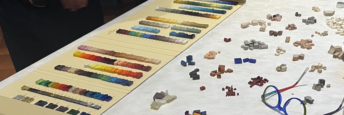 A variety of micro tile samples spread across a white table, grouped by color.