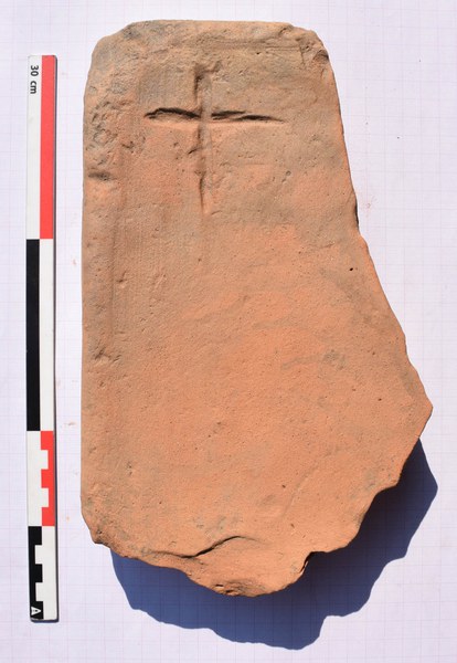 Brick with cross from grave C22. Photo by Anna Sitz.