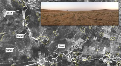 Fig. 3: CORONA photograph of a 100 m wide large canal and associated basin. Inset: ground photograph of canal interior, near Site 94, facing northeast. For scale, note the figures outside of the canal at left and right. 