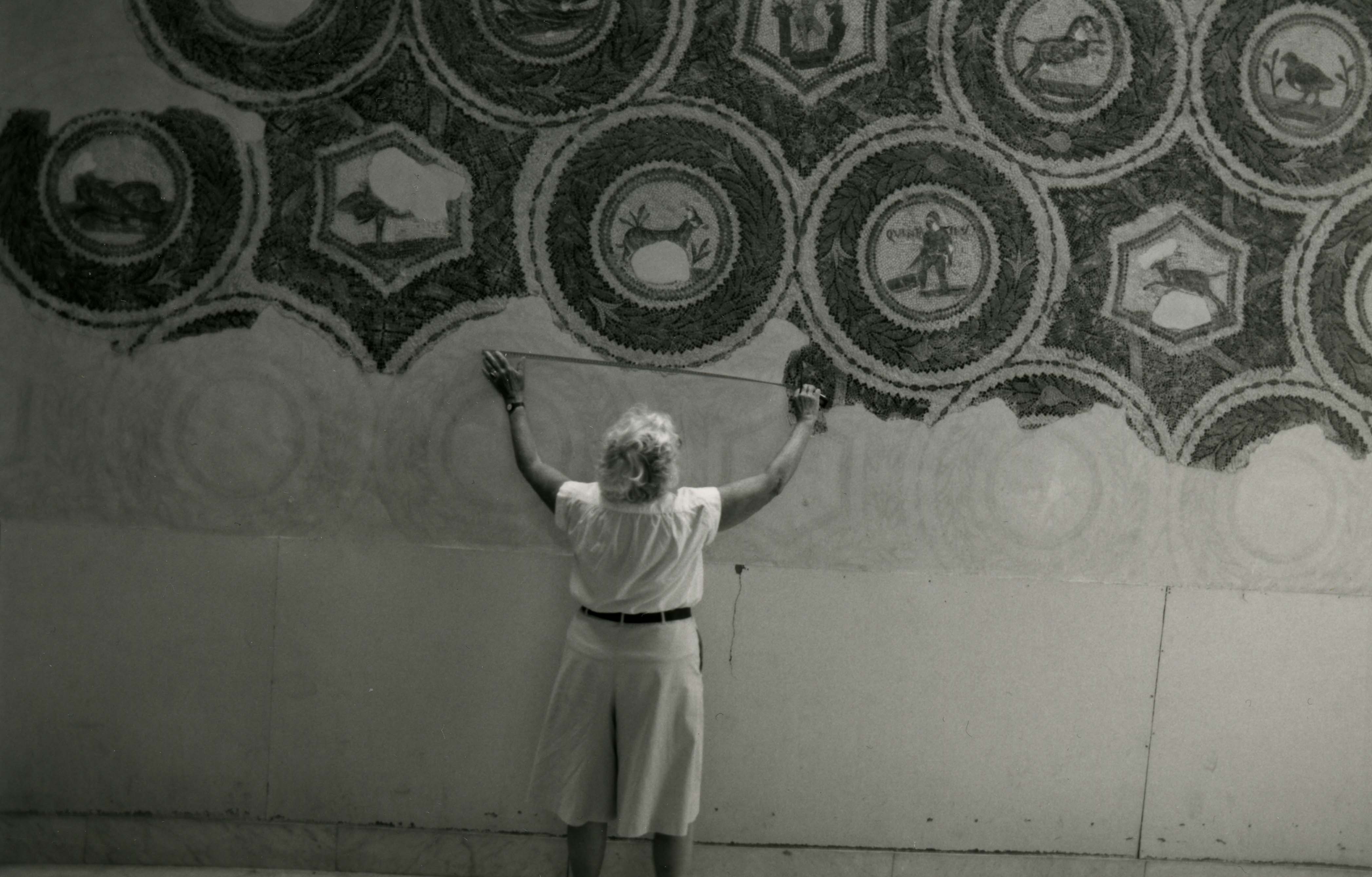 Margaret Alexander measuring a wall of mosaic