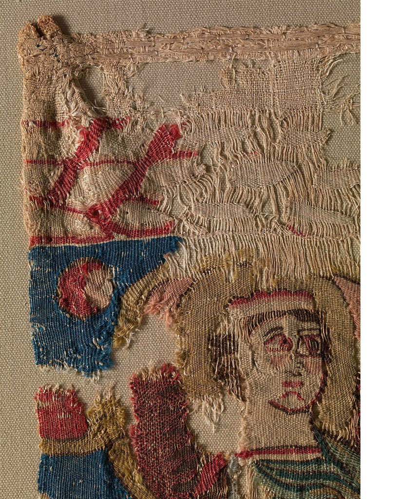 Detail of the upper-left corner of the fragment of Hanging with Riders, showing narrow strips of linen cloth sewn at an angle to the reverse of the hanging