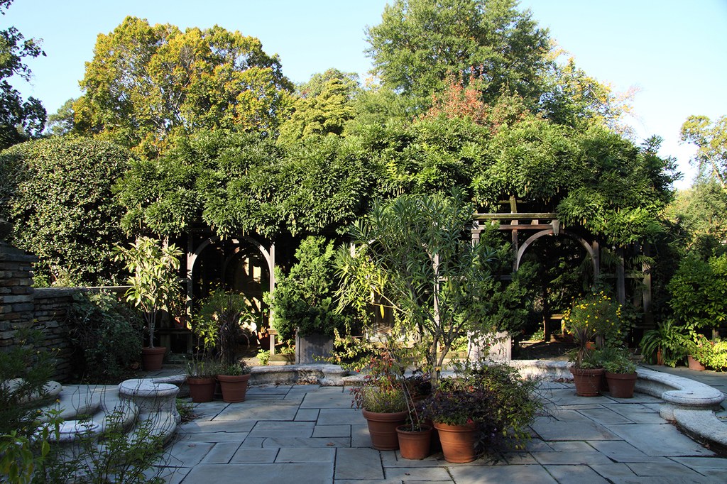View of the Arbor Terrace with potted plants in the corners and at the center of the paved area
