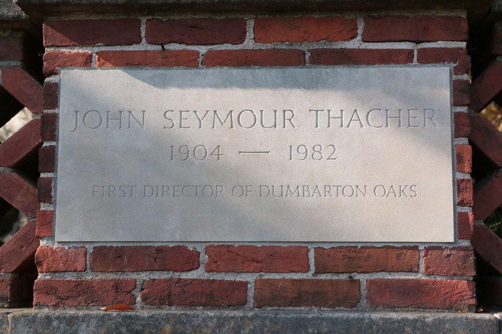 Commemorative plaque set into a brick wall and reading: John Seymour Thacher, 1904-1982, first director of Dumbarton Oaks