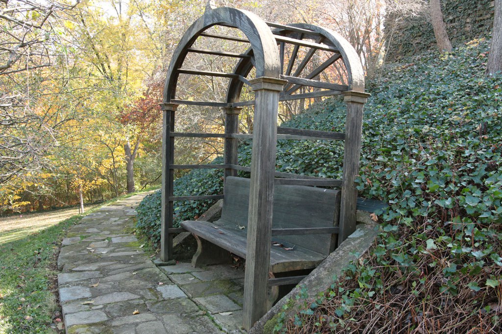Wooden bench with arbor along stone path