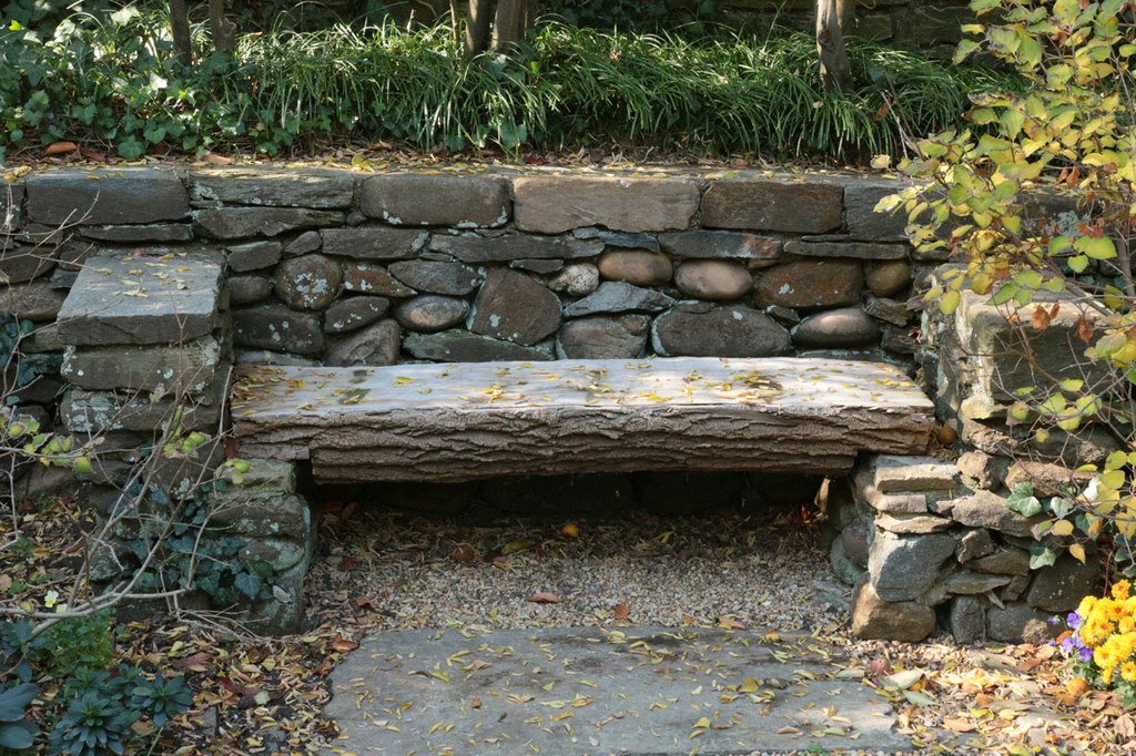 Wooden bench against a stone wall